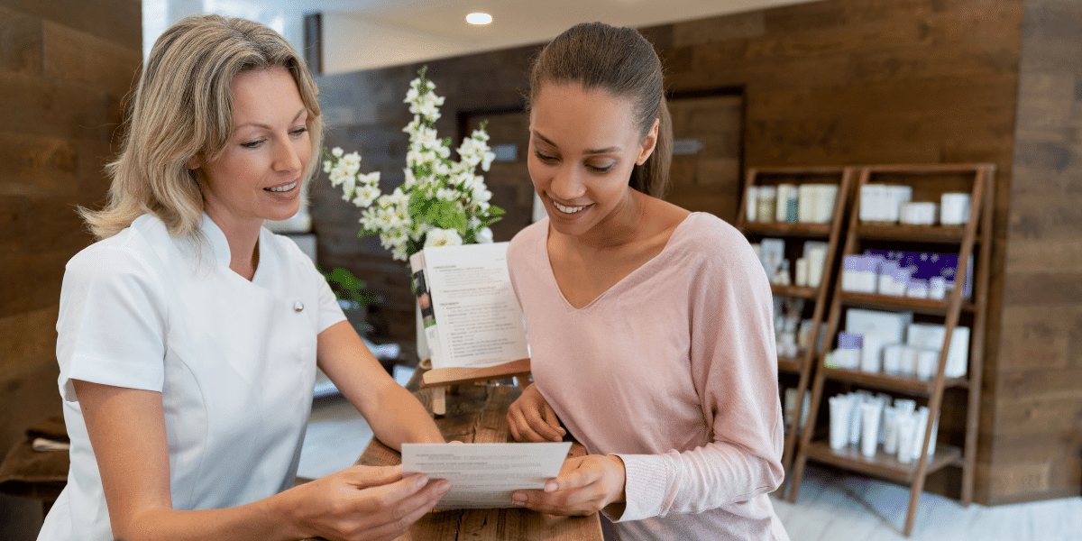 Two ladies looking over a document at a checkout counter