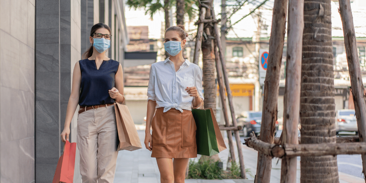 Two women walking outside with a mask on